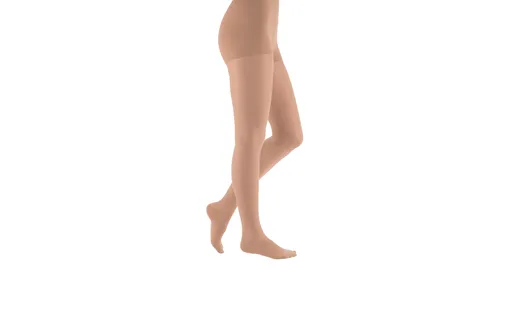 Ein Paar Beine trägt eine Strumpfhose in Karamellfarbe.
